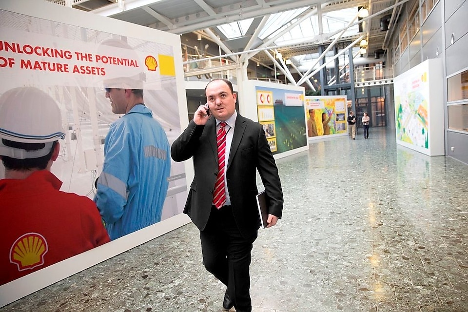 Andy Kneen přechází a&nbsp;mluví na telefonu v&nbsp;kanceláři společnosti Shell
