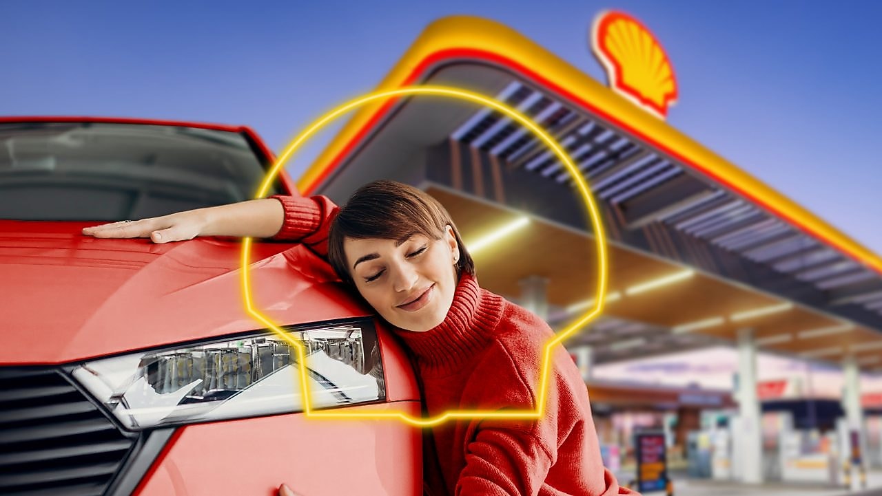 Paní objímá auto v obrysu loga Shell