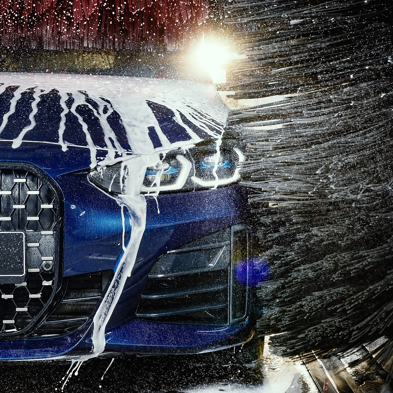 Modré auto v detailu projíždí Shell automyčkou