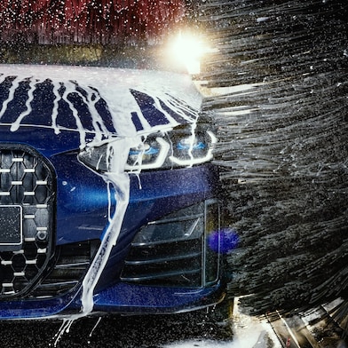 Modré auto v detailu projíždí Shell automyčkou