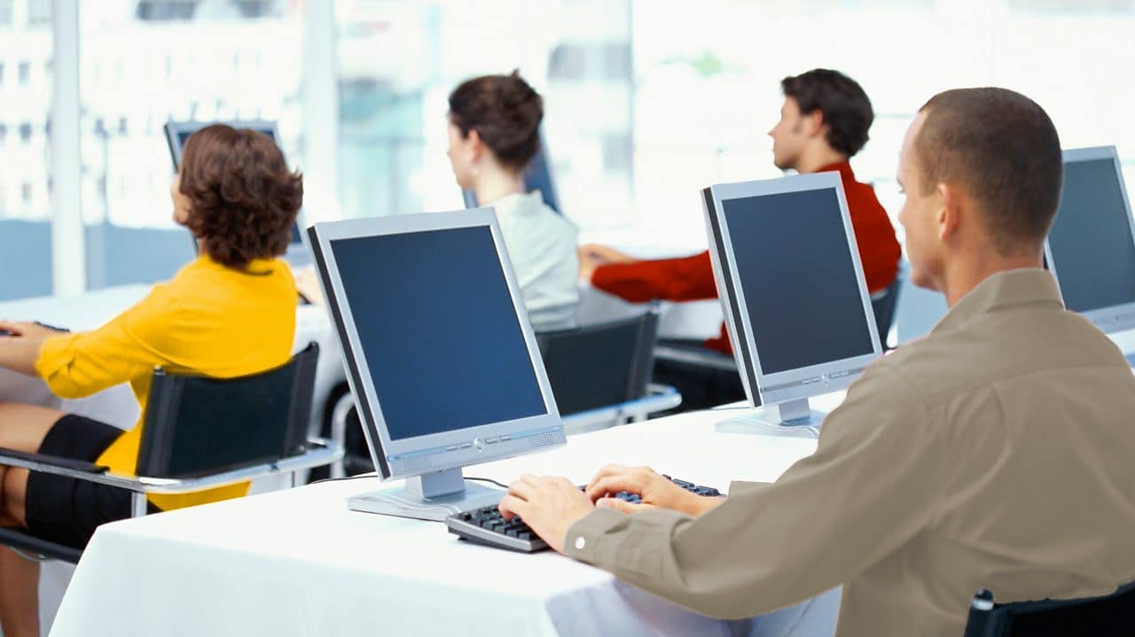 Zaměstnanci v kanceláři používající počítače