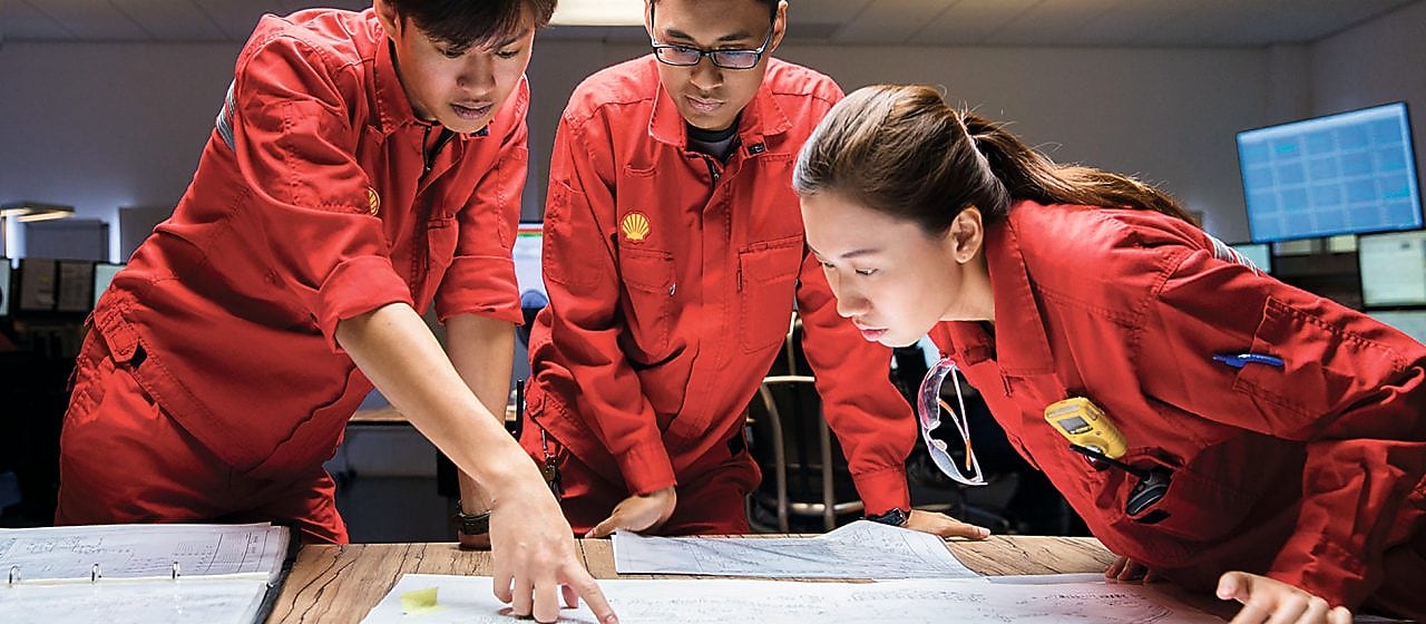 Tři zaměstnanci kontrolují plány