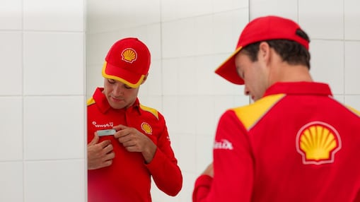 zaměstanec Shell čerpací stanice před zrcadlem