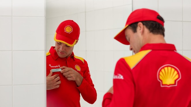 zaměstanec Shell čerpací stanice před zrcadlem