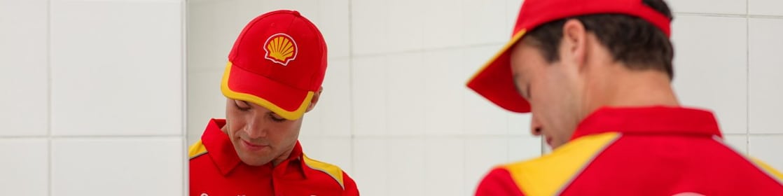zaměstanec Shell čerpací stanice před zrcadlem