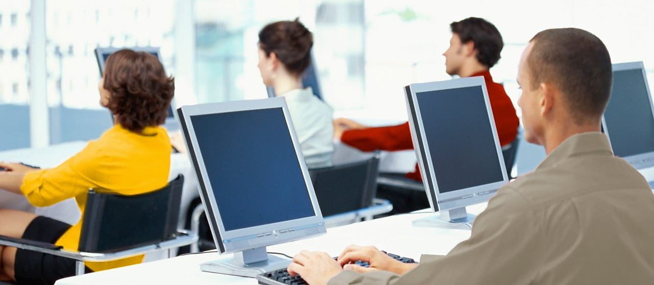 Zaměstnanci v kanceláři používající počítače