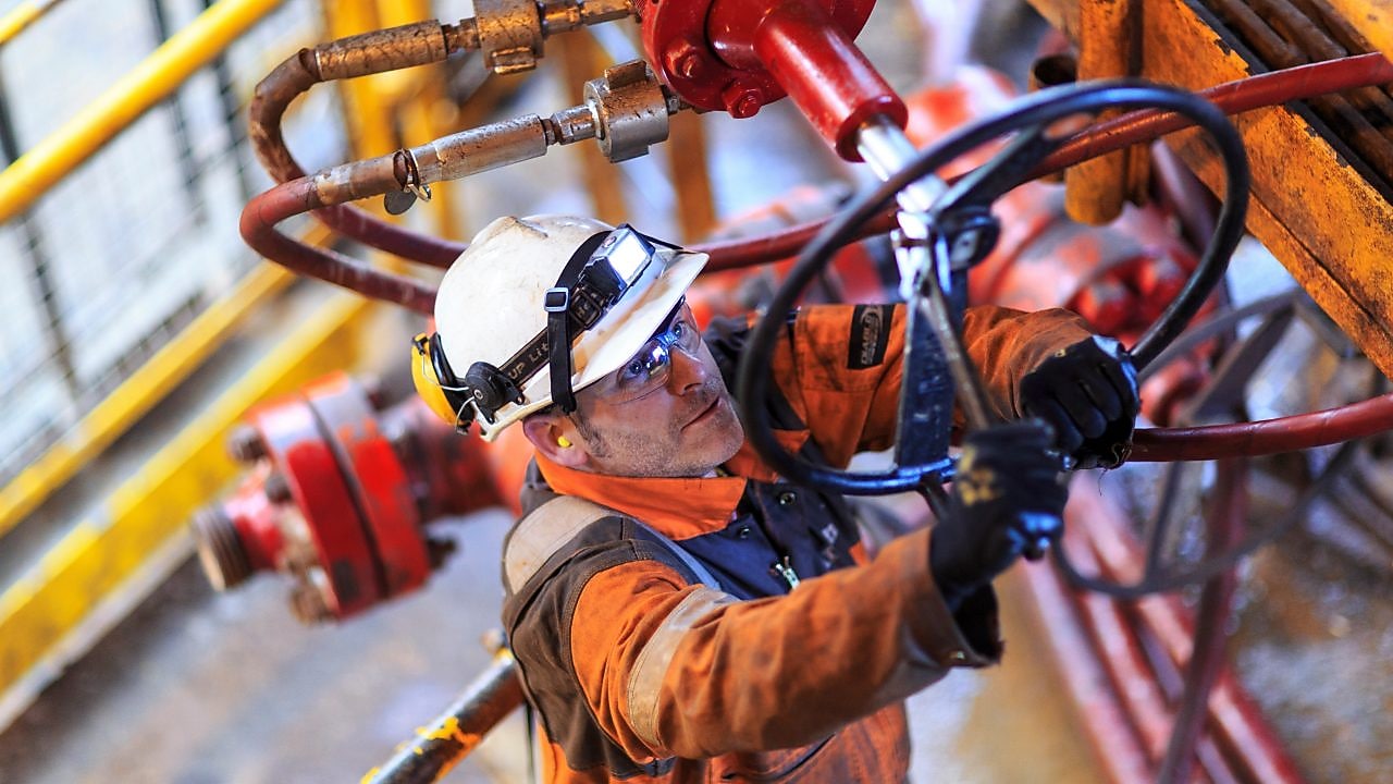 Muž pracující na plošině v&nbsp;bezpečnostní uniformě