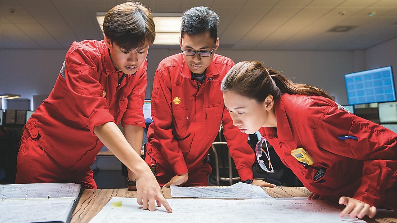 Tři zaměstnanci kontrolují plány