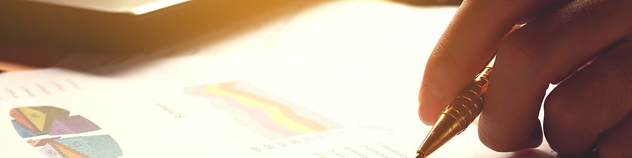 Hand holding pen and writing over graph paper