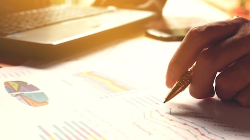 Hand holding pen and writing over graph paper