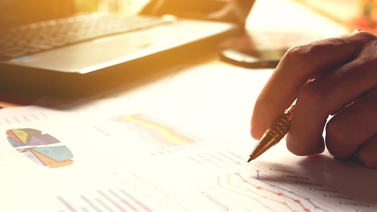 Hand holding pen and writing over graph paper