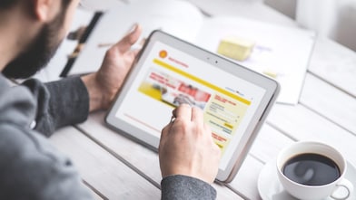 Někoho, kdo pracuje na jeho tabletu. Online portál Shell Card je na obrazovce tabletu.