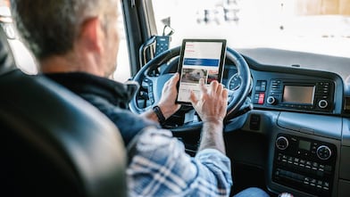 Řidič s mobilem v ruce s aplikací Shell SmartPay