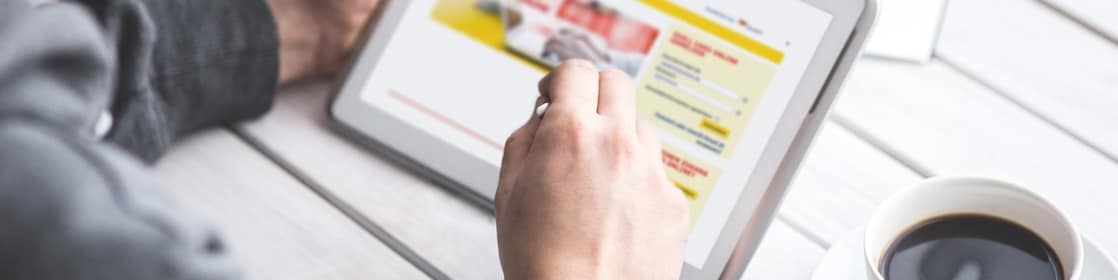 Někoho, kdo pracuje na jeho tabletu. Online portál Shell Card je na obrazovce tabletu.