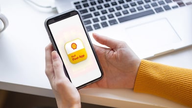 Ruce s mobilem ukazující Shell Fleet App