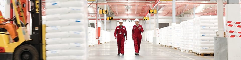 Dva zaměstnanci se prochází po továrně