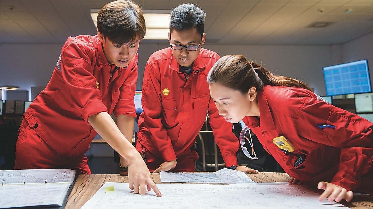 Tři zaměstnanci kontrolují plány