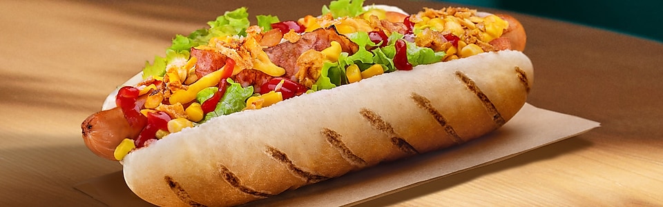 Nový hot dog Texas se sušenou cibuli, omáčky a kukuřici.