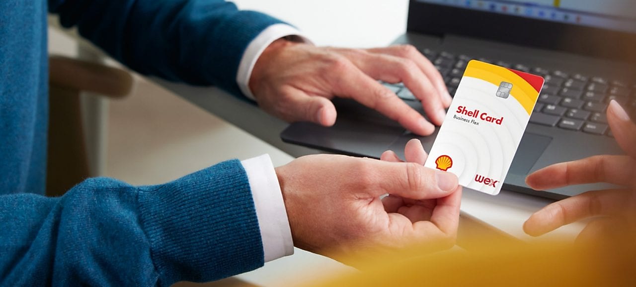 Foto muže, který drží v ruce hybridní kartu Shell 