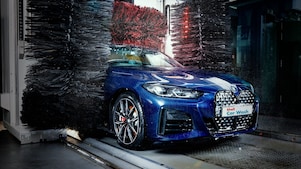 Modré auto v detailu projíždí Shell automyčkou.