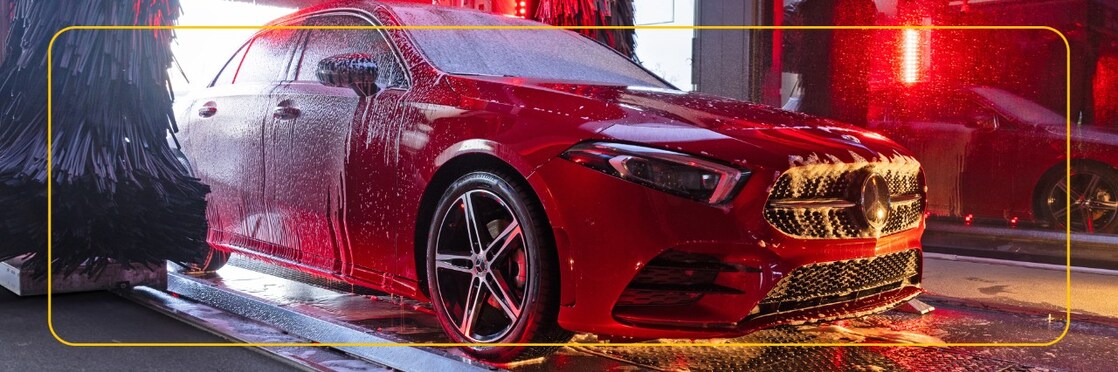 Červené auto v mycí lince Shell