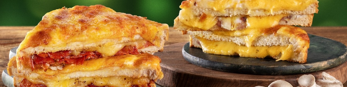 Foto dvou toustů na zeleném pozadí