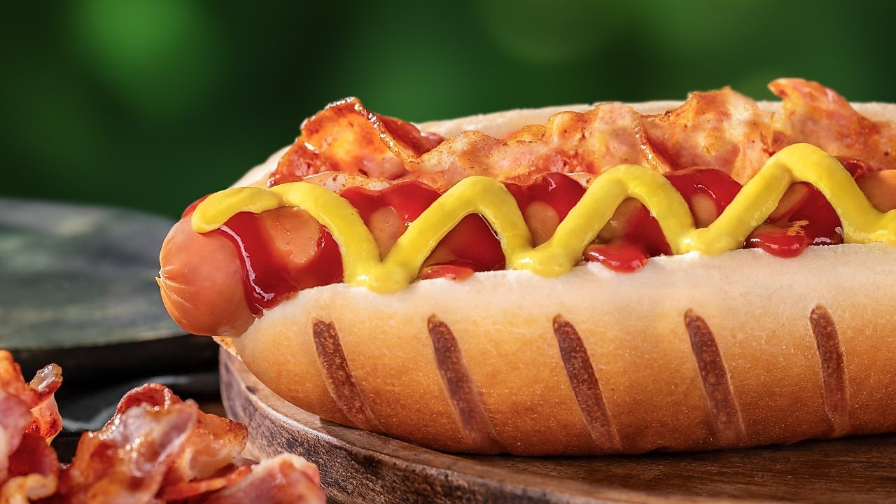 Foto hot dogu Amerika s párkem, se slaninou, hořčicí a kečupem