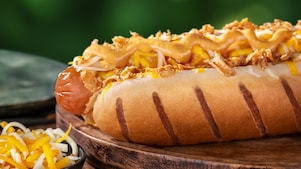 Foto hot dogu Francie s párkem, sýrem a karamelizovanou cibulkou