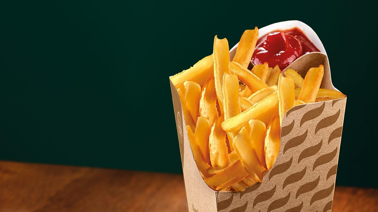 Foto hranolků s kečupem v papírovém obalu