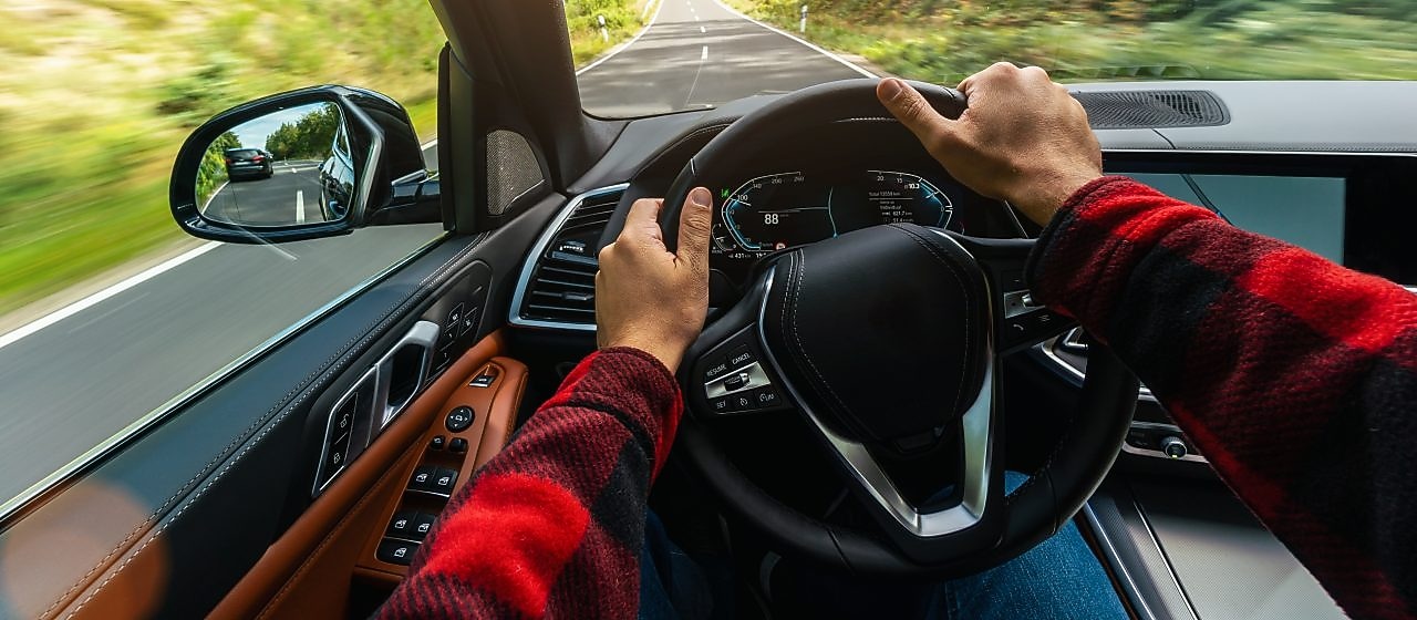 Auto prechádza krajinou, pohľad na krajinu z miesta vodiča cez čelné sklo.